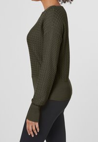 Pull en tricot vert foncé, présentant un motif texturé, des poignets côtelés et un ourlet ajusté. La vue de côté montre une coupe décontractée et le détail texturé.