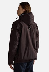 Brown insulated jacket with a hood, featuring a logo patch on the shoulder, smooth texture, and a zippered design at the hem.