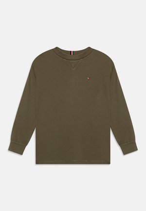 Chemise à manches longues vert olive en tissu doux, avec un col rond et un petit logo sur la poitrine. Poignets élastiques aux manches.