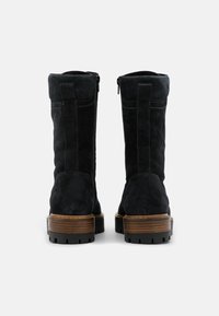 Stivali alla caviglia in suede nero con chiusura a zip, punta tonda e tacchi a blocco in legno. La parte posteriore presenta cuciture verticali e una parte superiore texture.