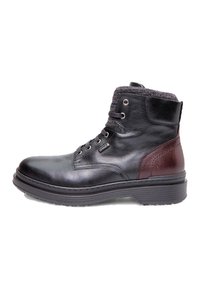 Stivale alla caviglia in pelle nera con tessuto in tessuto caratteristico grigio carbone al colletto, accenti in pelle marrone scuro e suola in gomma. La struttura con lacci presenta occhielli in metallo.