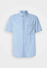 Camisa de manga corta de color azul claro hecha de mezclilla, con cuello abotonado, un bolsillo en el pecho y un dobladillo curvado.