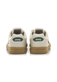 Sneakers bianchi con accenti verdi. Realizzati in materiale sintetico, presentano una suola in gomma testurizzata e un collare imbottito per il comfort. Logo del marchio visibile.