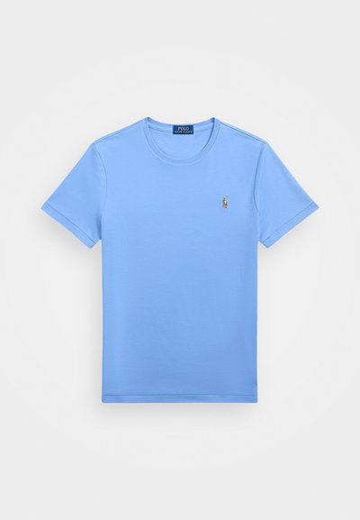 Camiseta de algodón de manga corta color azul claro con cuello redondo y logo bordado en el lado izquierdo del pecho. Textura suave y ajuste estándar.