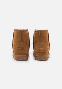 Brązowe zamszowe botki za kostkę z tanowym gumowym bieżnikiem. Cechy obejmują haftowane detale i teksturowaną tylną część. Logo widoczne na pięcie.