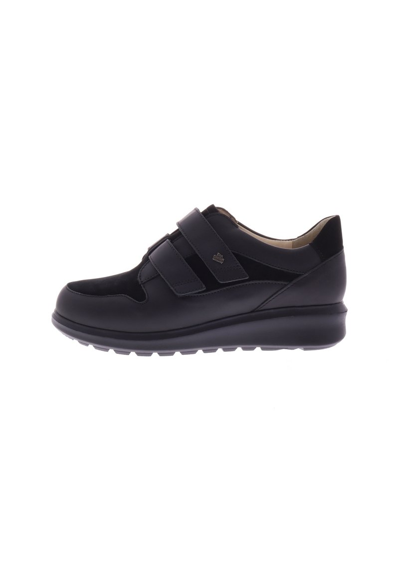 Zwarte sneaker met twee klittenbandsluitingen, gladde leren en suedetexturen, gevoerde zool, ronde neus en een subtiele logodetail.