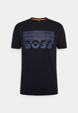 T-shirt noir à manches courtes avec col rond et un visuel rectangulaire bleu sur la poitrine affichant le texte répétitif "BOSS".