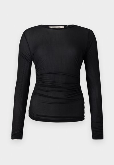 Črna dolga majica z dolgimi rokavi, izdelana iz prosojnega, raztegljivega materiala. Ima gubano obrobo ob straneh in okroglo izreza na vratu.