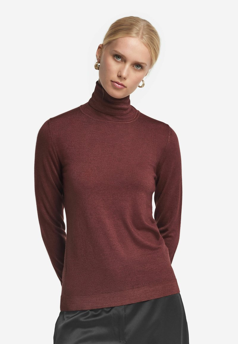 Vinröd polo tröja gjord av ett mjukt, texturerat tyg. Figursydd design med långa ärmar och ribbade manschetter. Slät finish, minimala sömmar.