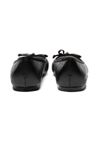 Ballerine nere con un motivo testurizzato, dettaglio con fiocco in raso nella parte anteriore, punta arrotondata e tacchi bassi. Finitura in pelle liscia.