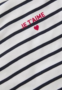 Niebiesko-biały, w paski bawełnowy T-shirt z napisem "JE T'AIME" na czerwono nad małym czerwonym sercem, o miękkim, teksturowanym wykończeniu.