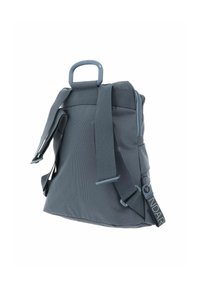 Sac à dos en tissu gris avec une finition texturée, des bretelles réglables et une poignée supérieure. Comprend un clip de fixation sur le côté et un détail de logo.