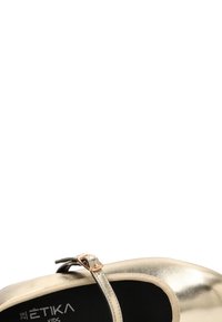 Zapato Mary Jane metálico dorado con punta redonda, correa elástica y pequeña hebilla decorativa. Textura suave y plantilla negra. Talla 28.