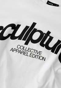 Hvid bomulds t-shirt med fed sort tekst, "sculpture COLLECTIVE APPAREL EDITION," med crew neck og en behagelig pasform.