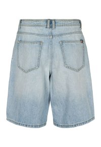 Short en denim bleu clair avec deux poches arrière et passants pour ceinture, avec une petite étiquette en tissu sur la poche droite.