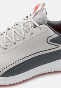 Hellgraue Sneaker mit einem strukturierten Mesh-Obermaterial, kontrastierenden dunkelgrauen Akzenten und weißer Sohle. Verfügt über dekorative Nähte und kontrastierende Schnürsenkel.