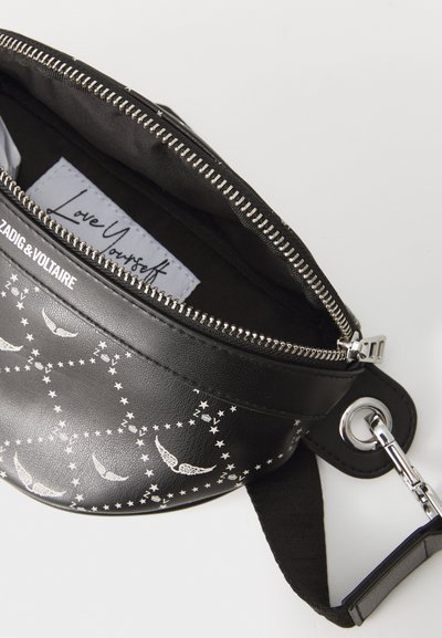 Sac en cuir noir avec un motif d'étoile et d'ailes argentées. Il dispose d'une fermeture éclair et d'une bandoulière détachable. L'intérieur comporte une étiquette de marque.