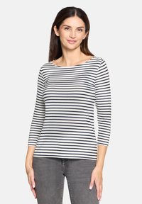 Gestreiftes Langarmoberteil in Creme und Marineblau, mit weitem Ausschnitt und weichem Stoff, kombiniert mit grauen Jeans.