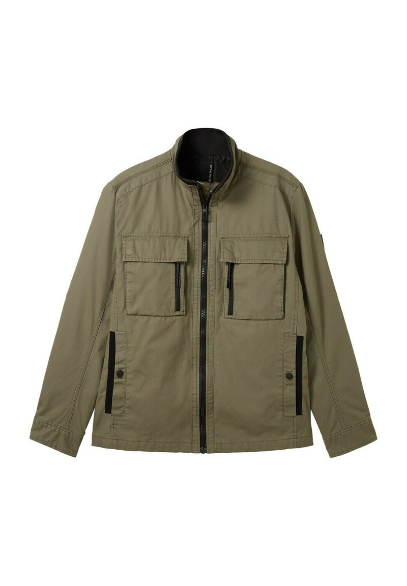 Chaqueta de cremallera verde oliva hecha de una tela ligera. Presenta dos bolsillos en el pecho y bolsillos laterales con acentos de hardware negro.