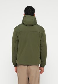 Olive green puffer jacket with a hood, featuring elastic cuffs and a smooth texture. Back view highlights a simple design with no visible hardware.
