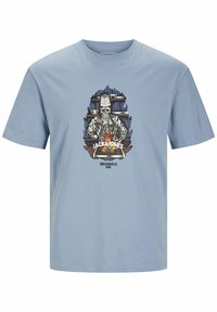 Világoskék pamut póló, amelyen egy szakács csontváz grafikai tervezése látható tűz mellett, az alján pedig a "JACK & JONES ORIGINALS" szöveg szerepel.