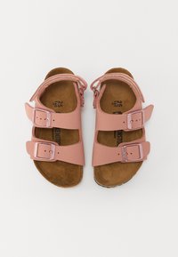 Rosa sandaler med två justerbara remmar, gjorda av glatt syntetiskt material. Har en formad korkfotbädd och spännen i silverfärg.
