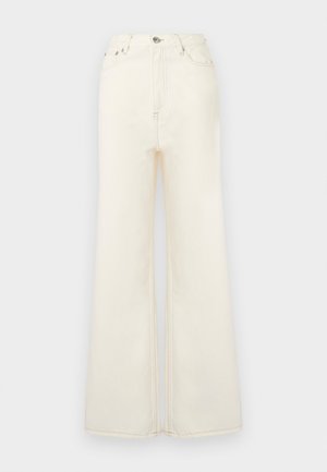 Vaalean kermaan vivahtavat, korkeavyötäröiset ja liehuvat farkut, valmistettu denimistä. Ominaisuuksiin kuuluu etutaskut, nappi- ja vetoketjusuljenta sekä näkyvät saumat.