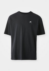 Black cotton t-shirt with short sleeves, crew neck, featuring a small rectangular logo with "NIKE AIR" in white on the left chest.