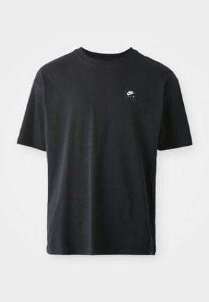 T-shirt en coton noir à manches courtes, col ras du cou, arborant un petit logo rectangulaire avec "NIKE AIR" en blanc sur la poitrine gauche.
