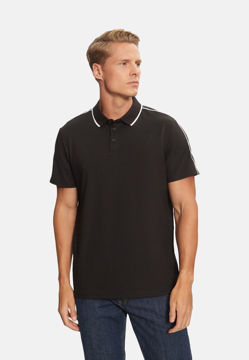 Camisa polo negra con una tapeta de tres botones, cuello blanco y acentos a rayas en los hombros. Manga corta, textura de tela suave.
