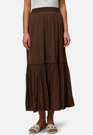 Jupe maxi en couches de couleur brune, fabriquée en tissu léger avec une taille élastique, dotée d'un design fluide et d'une surface texturée.