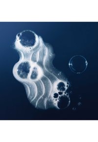 Clusters of translucent soap bubbles with reflective surfaces float on a dark blue liquid background.