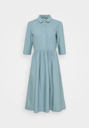 Halskragen, knielanges Kleid aus leichtem Baumwollstoff. Mit durchgehender Knopfleiste, Dreiviertelärmeln und einer kleinen Brusttasche. Volantrock.