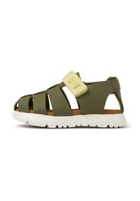Grön lädersandal med utskärningsdesign, justerbar gul rem och vit sula. Platt, stängd tå, lämplig för avslappnad användning.