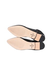 Ballerine in pelle nera con punta affusolata, texture liscia e suola in gomma beige chiaro con leggero rigatura e marchio impressa.