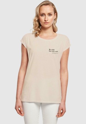 Beige Baumwoll-T-Shirt mit kurzen Ärmeln, rundem Ausschnitt und einem gedruckten Zitat in Schwarz auf der Vorderseite. Glatte Textur, lockere Passform.