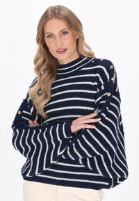 Navy- und weiß gestreifter Strickpullover mit hohem Hals, übergroßen Ärmeln und dekorativen goldenen Knöpfen an den Schultern.