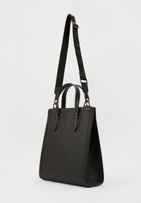 Black leather tote bag with a structured shape, flat base, dual top handles, and an adjustable shoulder strap. Smooth texture with minimal accents.