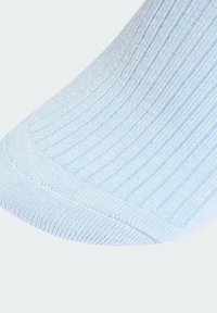 Svetlomodrá rebrovaná ponožka s textúrovaným povrchom, s zakrivenou špičkou a tesným strihom. Materiál vyzerá jemne a elasticky.