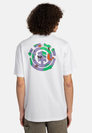 T-shirt in cotone bianco con un design grafico colorato sul retro, che rappresenta insetti e vegetazione in tonalità di viola e verde.