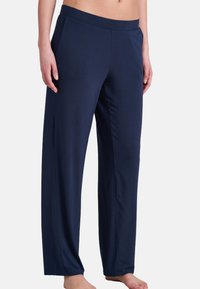 Pantalons de lounge légers bleu marine avec une coupe relaxée, taille élastique et poches latérales ; texture lisse avec un éclat subtil.