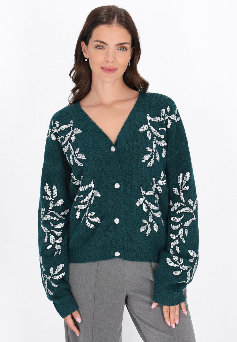 Cardigan de punto en teal con escote en V, con patrones florales de lentejuelas plateadas en las mangas. Cierre delantero de botones y puños acanalados.