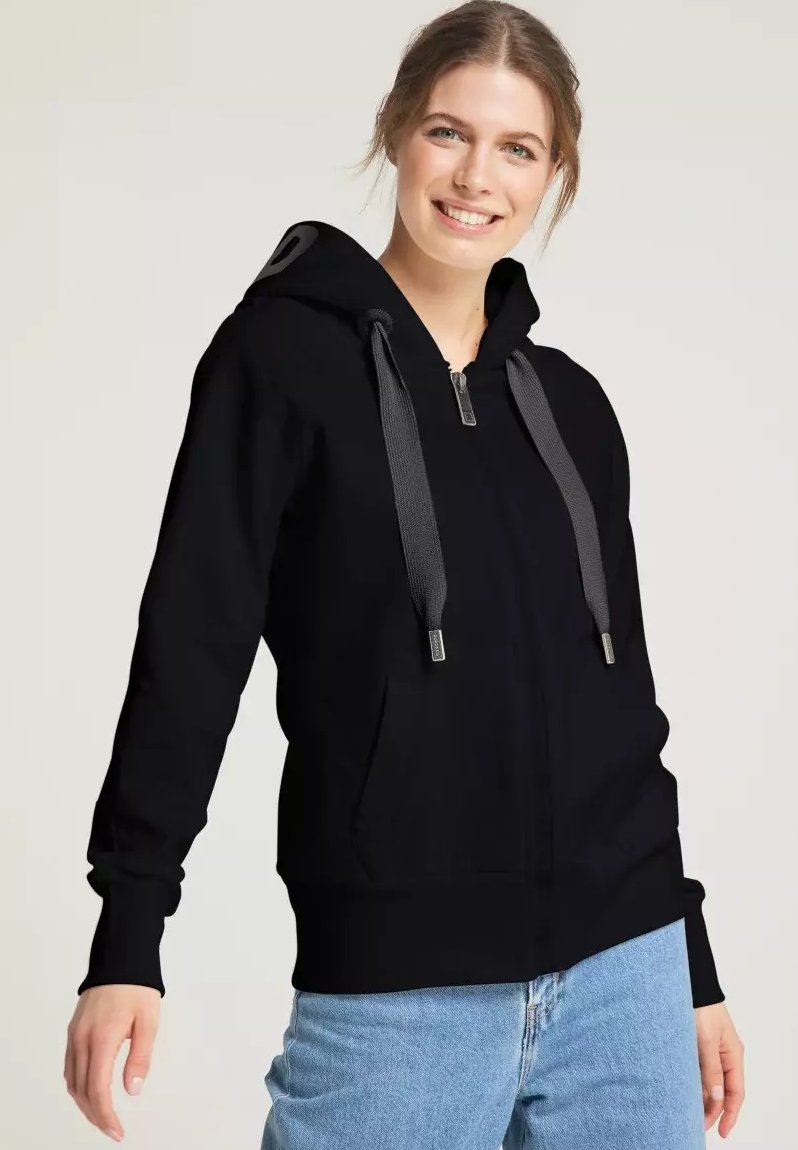 Schwarze Zip-Hoodie mit Kapuze, grauen Kordeln und Fronttaschen. Weicher Stoff, lässige Passform, kombiniert mit hellblauen Jeans.