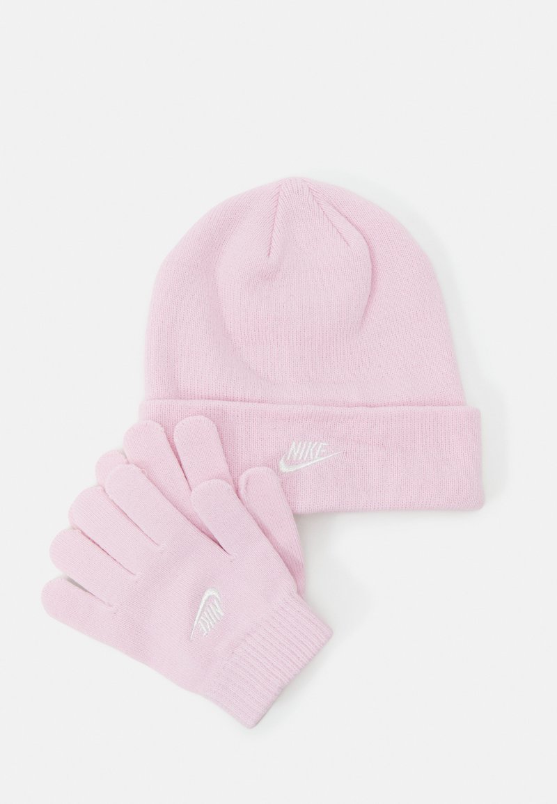 Hellrosa gestrickte Mütze mit umgeschlagenem Bündchen und passendem Handschuhen. Beide verfügen über weiße Nike-Logos. Weicher Stoff, standardmäßige Passform.