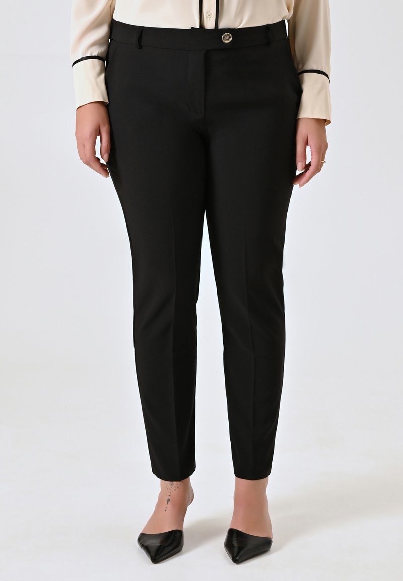 Pantalons noirs sur mesure avec une coupe droite, présentant une fermeture à bouton et des poches latérales. Tissu lisse avec une finition élégante.