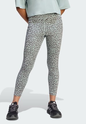 Animal print leggings featuring a grey base with light blue leopard spots, made of stretchy material. Paired with black athletic shoes.