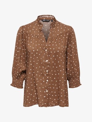Blouse marron à pois blancs, boutonnée sur le devant, manches 3/4 froncées et col à volants.