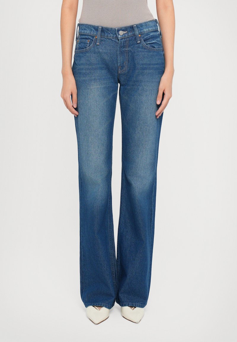 Jeans in medium blue denim, met een hoge taille, wijde pijpen en een lichte vervaging. Zichtbare metalen knoop en klinknagels.