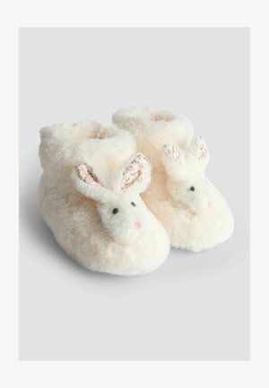 Papuci pufoși, roz pal, în formă de iepurași, cu urechi cu model floral, ochi negri de buton și o textură moale din pluș.