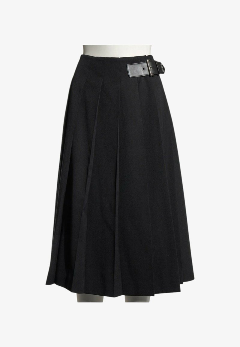 Jupe plissée noire longueur genou avec une large ceinture et une grande boucle rectangulaire sur le côté droit, présentée sur un buste de mannequin blanc.